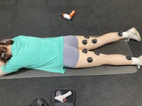 a woman laying on a mat with a massage ball on her back